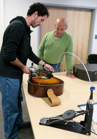 CanAssist's Mike Lewis readies the Guitar Strummer for Charles.
