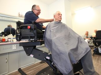 Bob cuts the hair of his friend, John Harrison.