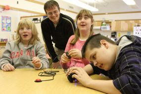 Carl (standing) delivers the music player and adapter to a local school.