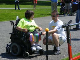 Nathanael helps Brandi prepare to take a swing.